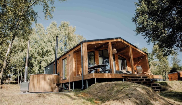 Atmospheric Scandi by the lake for 5 people, with private hot tub, wood-burning stoves, spacious veranda, and plenty of nature and resort facilities within easy reach.
